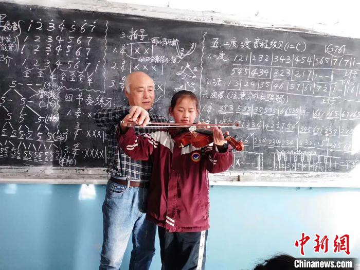 圖為趙興洲教學生拉小提琴。受訪者提供