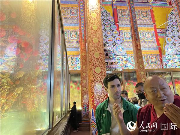 7月25日，省級非物質(zhì)文化遺產(chǎn)項目塔爾寺酥油花的代表性傳承人朋措堅參（右）在塔爾寺酥油花館講解酥油花的制作過程。人民網(wǎng) 謝瑩攝