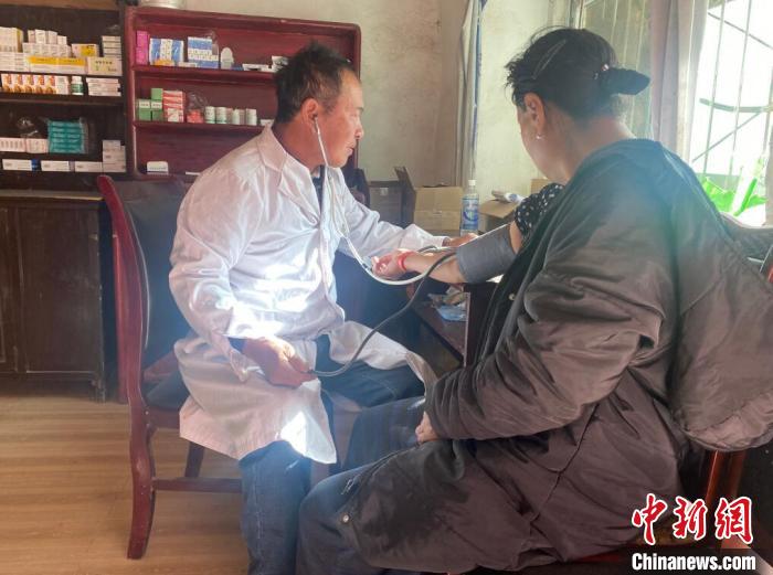 索木滾(左)為村民看病?！∪捞量h委宣傳部供圖