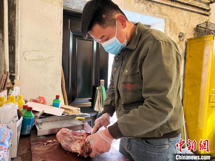 圖為雪豹“奶爸”史壽軍正在準(zhǔn)備投喂雪豹的食材?！●R銘言 攝