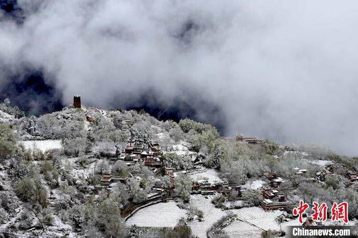 雪后的藏寨和碉樓構(gòu)成美麗的雪景?！〗党鯘衫?攝