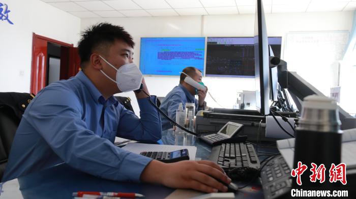 圖為貨運調(diào)度人員與外勤工作人員聯(lián)系掌握車輛裝載情況。　李生燕 攝