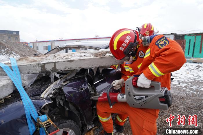 圖為地震實(shí)戰(zhàn)拉動現(xiàn)場，參演人員進(jìn)行車輛破拆?！∮駱湎拦﹫D