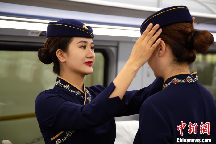 圖為青藏鐵路西格段“復興號”動車組乘務員互相整理新制服?！±罾?攝
