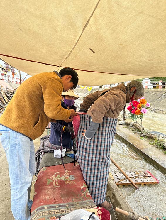 扎西奪爾登為路邊老人送去保暖圍腰。阿壩州文明辦供圖
