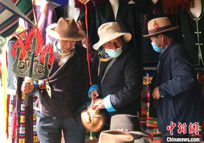 圖為三位藏族老人在集市上聊天交談?！∪轿木?攝