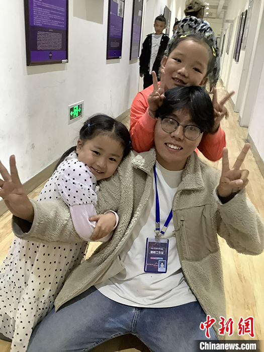 “Z世代”旦真旺加認為，拉薩是一座開放與包容的城市，記憶中的拉薩是彩色的。2021年，旦真旺加從浙江大學漢語言文學專業(yè)畢業(yè)后，他選擇回到拉薩，成為一名漢語文實習助教。圖為8月4日，旦真旺加在課間陪學生玩耍。 <a target='_blank' ><p  align=