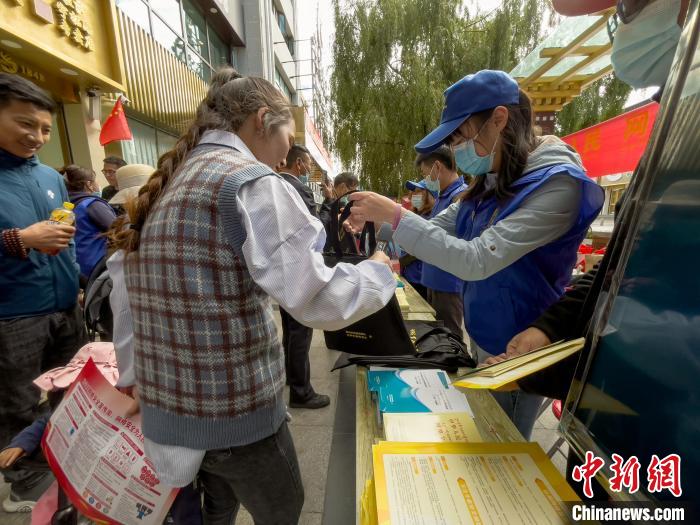 圖為志愿者為市民發(fā)放網(wǎng)絡(luò)安全宣傳手冊。　謝牧 攝