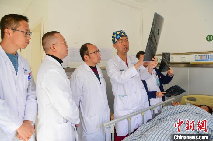 圖為醫(yī)療援藏專家何蔚(站右二)與馮敬云(左二)、廖濤(左三)等人討論患者病情。(資料圖) 貢嘎來松 攝