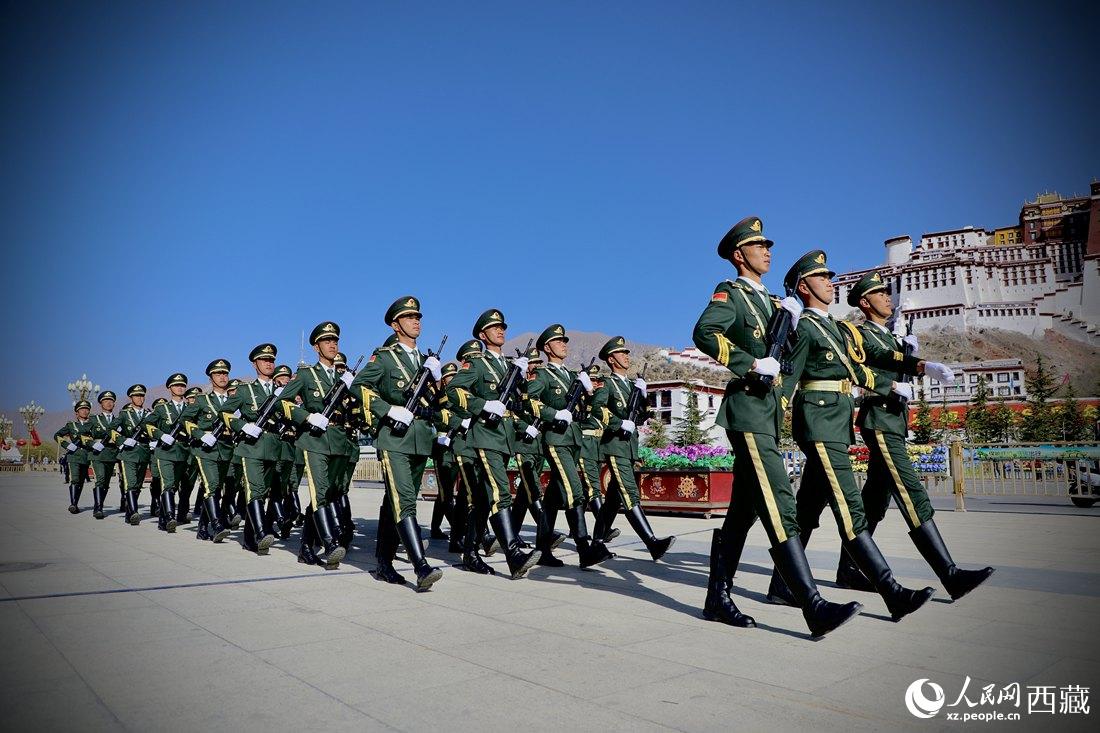 國(guó)旗護(hù)衛(wèi)隊(duì)隊(duì)員緊握鋼槍，踏著威武雄壯的步伐，走向國(guó)旗臺(tái)。人民網(wǎng) 次仁羅布攝