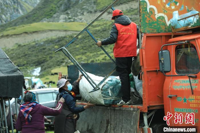 圖為工作人員幫助牧民們卸家具?！÷蹇?攝