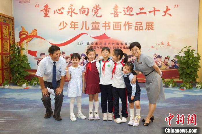 圖為與會嘉賓與入選畫作的“小作者”們在展覽上合影?！≈袊貙W研究中心供圖