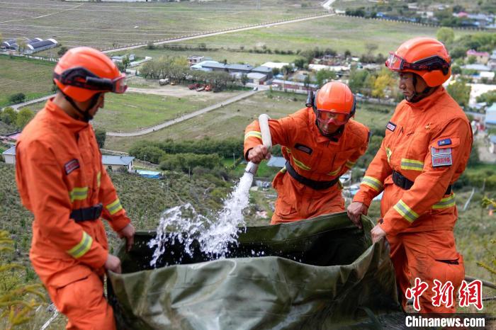 技能大練兵過程中，消防員在陡坡上向蓄水池注水?！±顕鵂c 攝