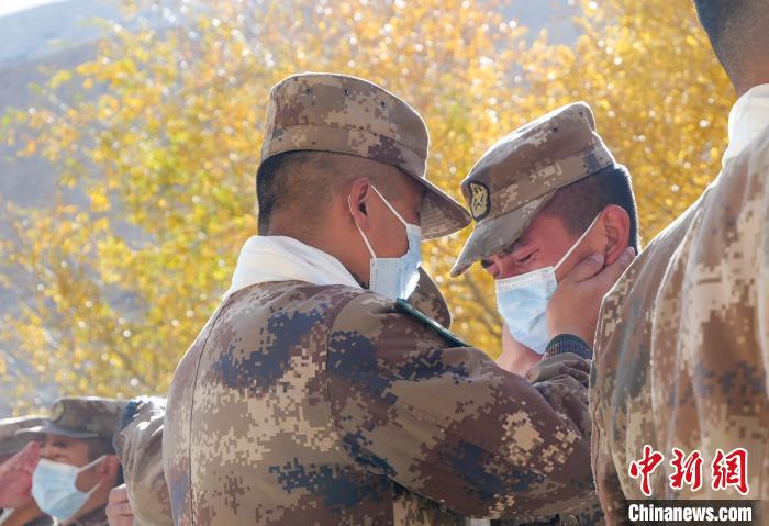 圖為什布奇邊防連退伍老兵與戰(zhàn)友相擁而泣，依依惜別?！⌒觳?攝