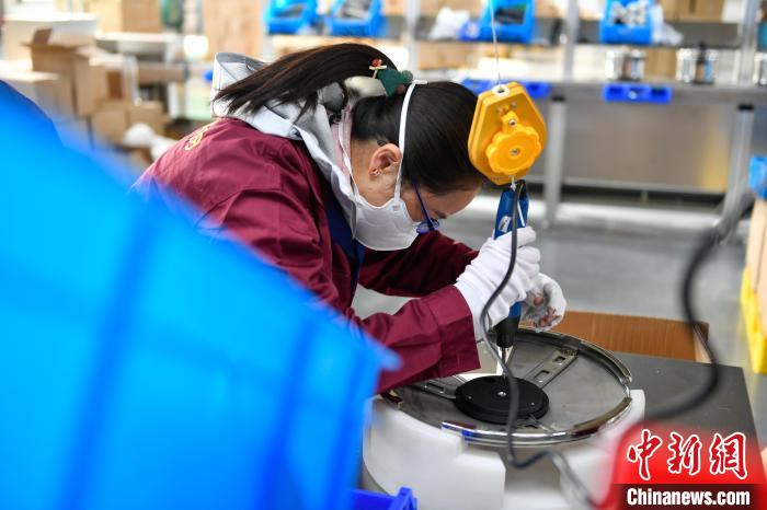 圖為工人正在組裝炊具。　貢嘎來松 攝