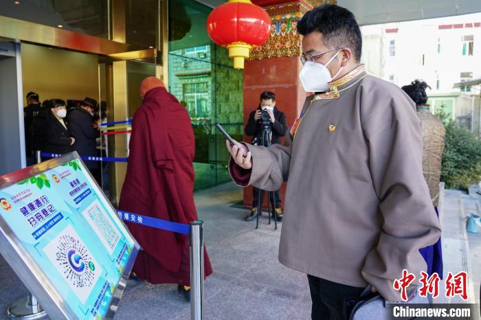 圖為政協(xié)委員掃場所碼進入會場。　江飛波 攝