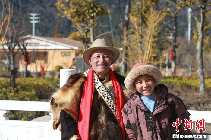 圖為林芝市巴宜區(qū)布久鄉(xiāng)仲果村村民桑杰與孫子一起參加藏歷新年活動?！埩?攝