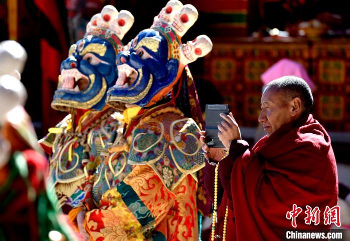 2月19日，正在拍攝跳神活動(dòng)的僧人?！±盍?攝