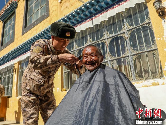 圖為阿里軍分區(qū)某邊防團(tuán)官兵為駐地群眾理發(fā)迎藏歷新年?！〉┰鰝愔?攝