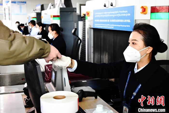圖為機(jī)場工作人員為旅客辦理行李托運(yùn)。　周航 攝