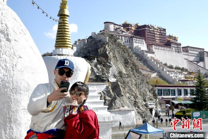 4月17日，游客身著藏式元素服裝在拉薩布達(dá)拉宮觀景臺(tái)拍照留念?！±盍?攝