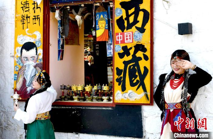 4月17日，游客身著藏式元素服裝在拉薩八廓街拍照留念?！±盍?攝
