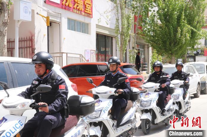 民警騎著電瓶車在轄區(qū)巡邏走訪。　黃創(chuàng)偉 攝