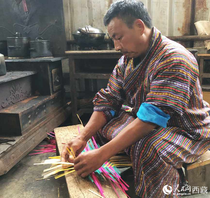 門巴族漢子愛明正在編織藤竹品。
