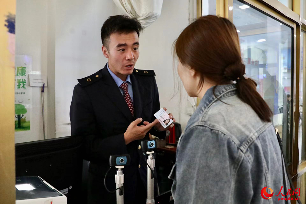 車站工作人員向旅客解答疑問。人民網(wǎng)記者 次仁羅布攝