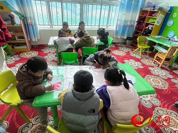 拉多村一所現(xiàn)代化幼兒園小班孩子們正在繪畫(huà)。張敏穎 攝