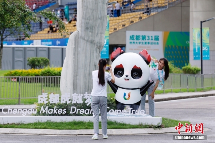 志愿者在比賽場(chǎng)館外與吉祥物景觀合影。<a target='_blank' href='/'><p  align=